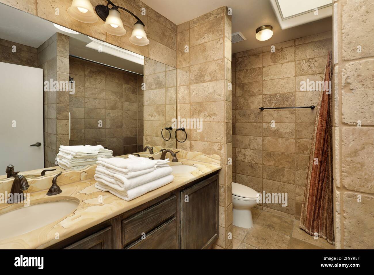 Bagno in casa di lusso con vanity in marmo e lucernario Foto Stock