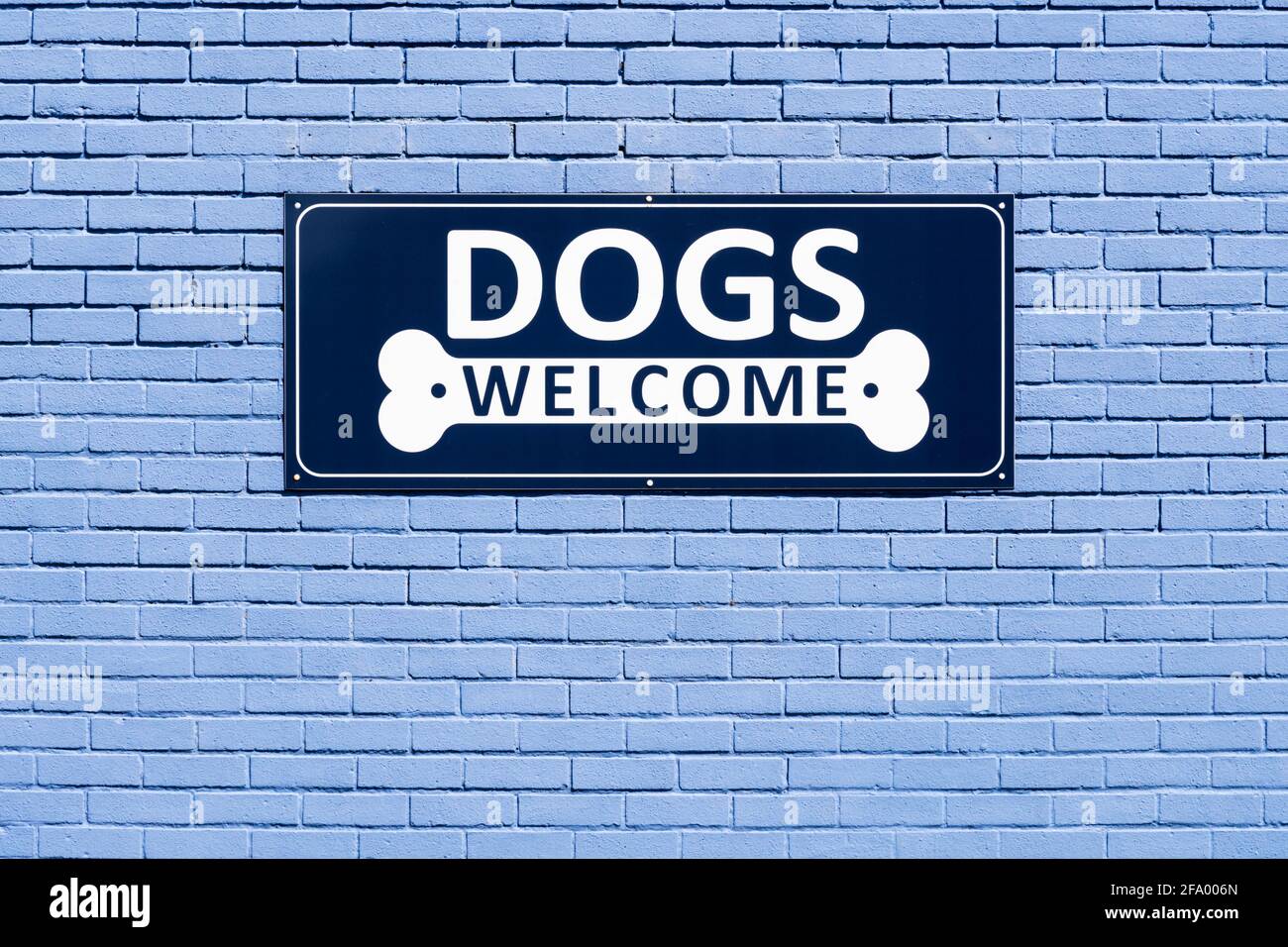 Cartello di benvenuto per cani sul lato di un bar. Foto Stock