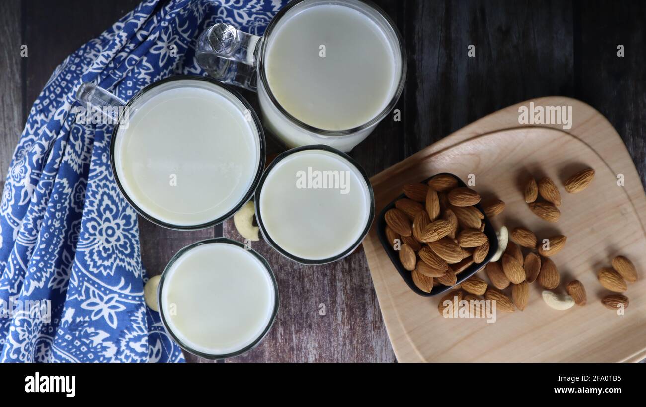 Latte vaccino, un'eccellente fonte di proteine, bevande popolari, isolato su sfondo scuro, sfondo di legno Foto Stock