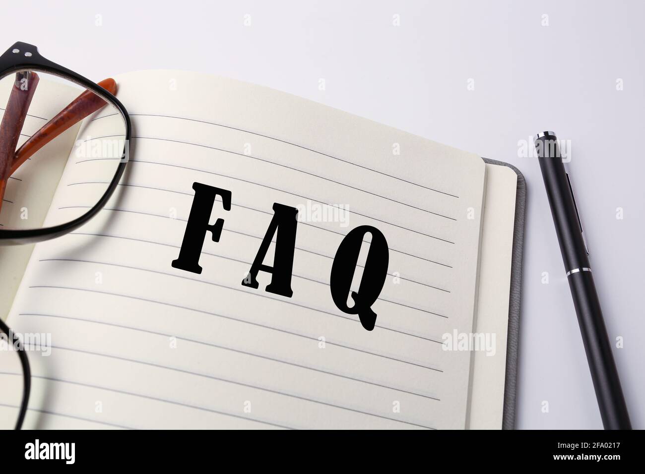 FAQ scritte su un notebook. Foto Stock