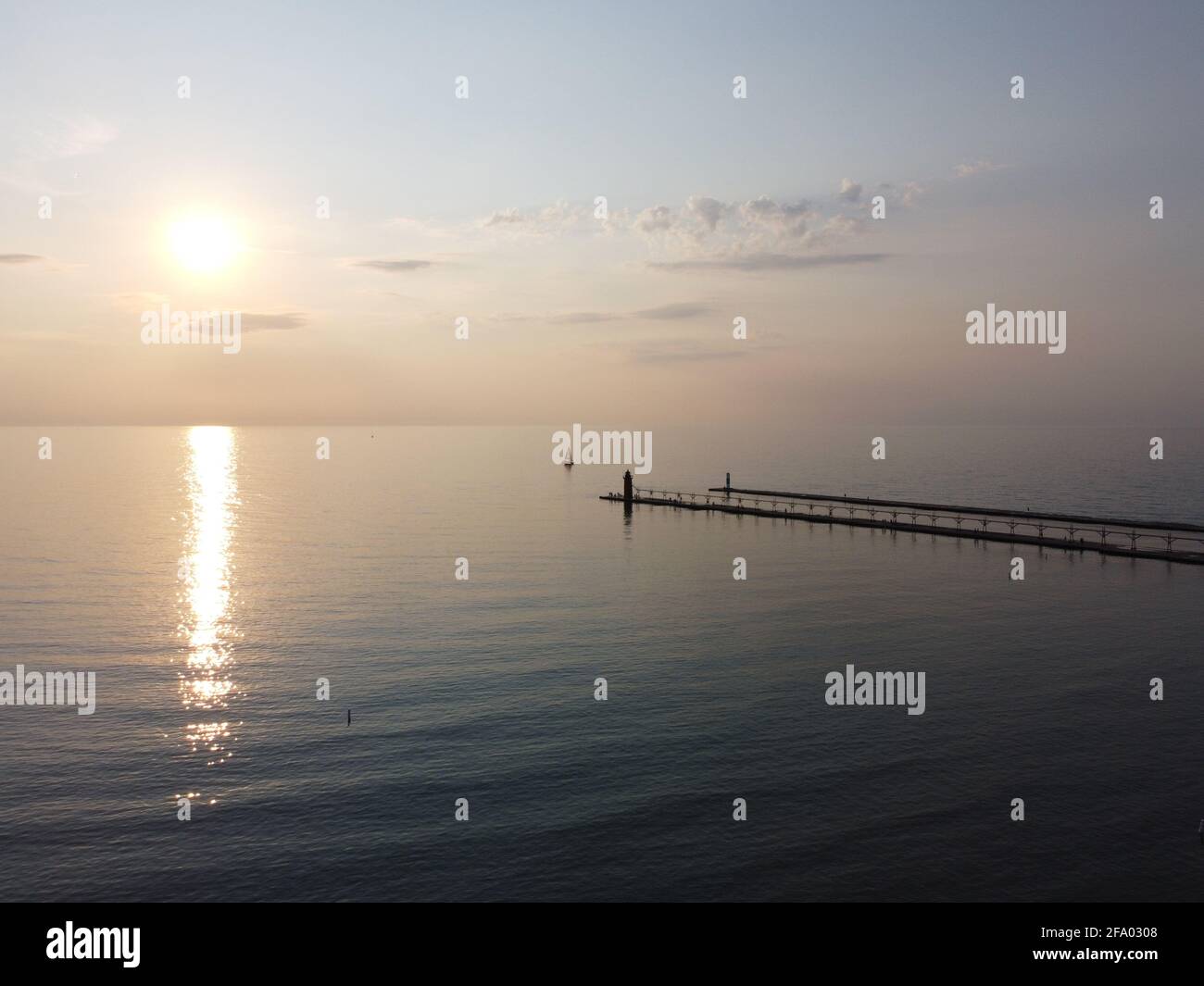 Vista in lontananza del faro di South Haven durante il tramonto. Foto Stock