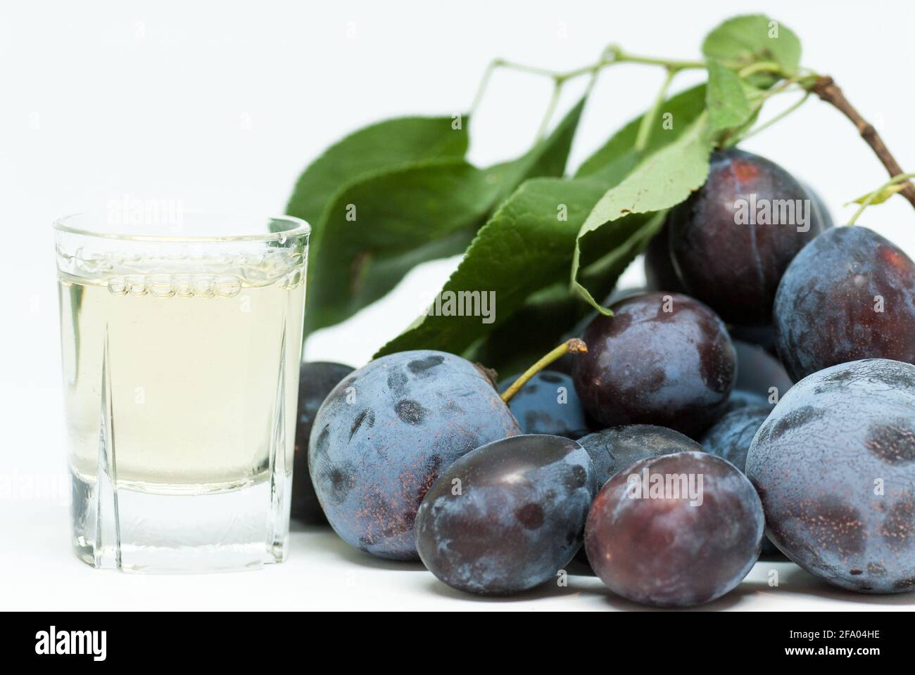 bicchiere con brandy di prugne e cumulo di prugne da parte Foto Stock
