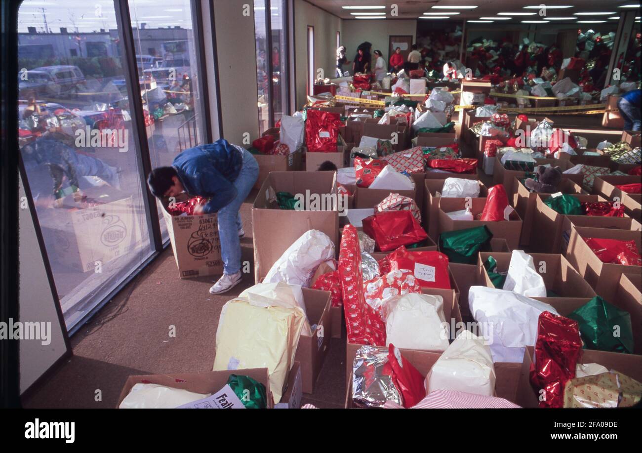 Austin, TX USA: Il volontario ordina i regali in magazzino pieni di regali di Natale per la festa sponsorizzata dalla polizia della città in omaggio per le famiglie a basso reddito. ©Bob Daemmrich Foto Stock
