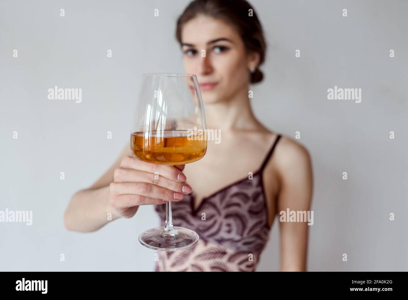 Donna carina gustando un bicchiere di vino bianco. Copia spazio, sfondo, spazio negativo per sovrapposizione testo, persone reali, elemento umano, estate, toast, bevande, c Foto Stock