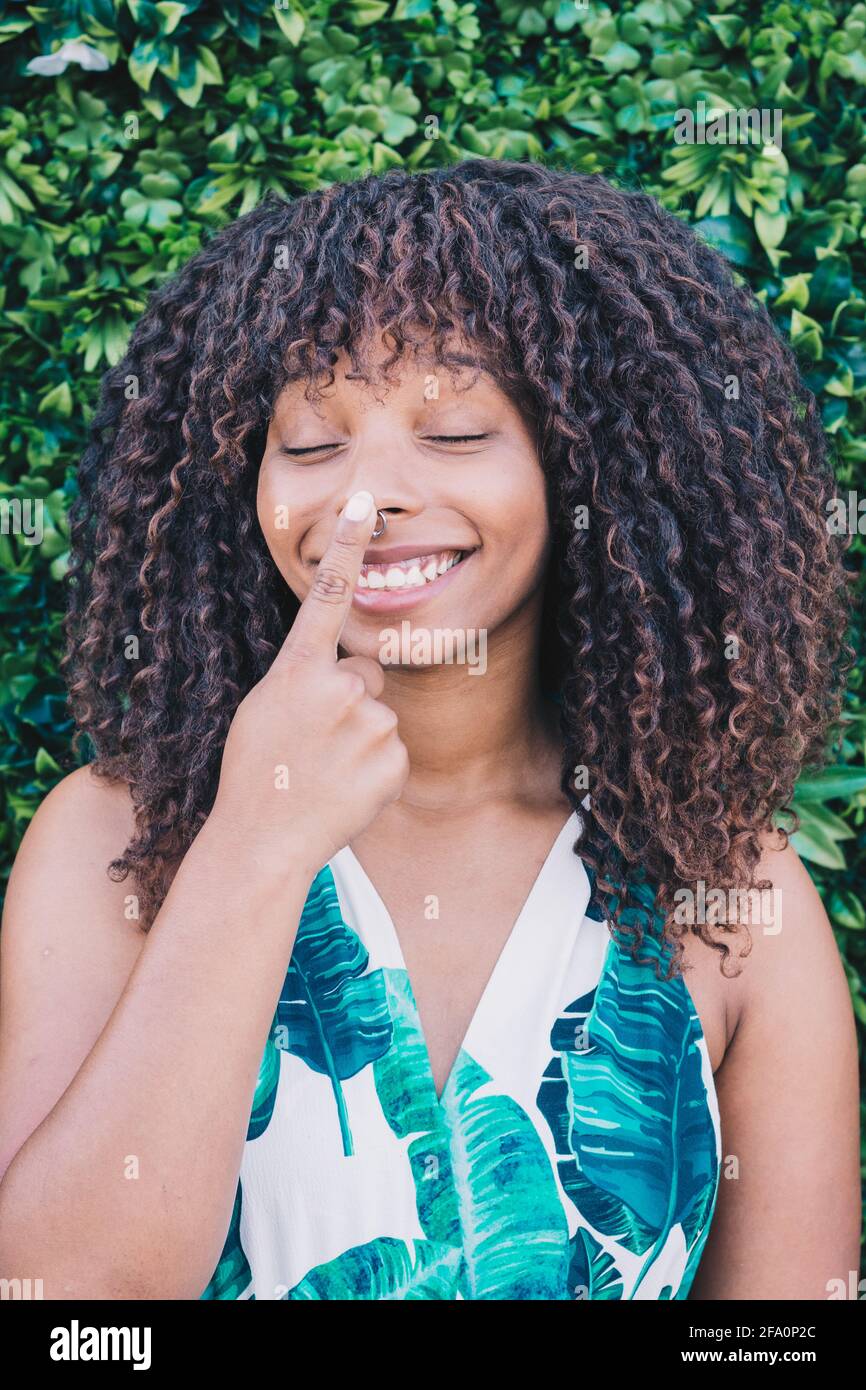 Ritratto di una donna africana sorridente e toccante il naso Foto Stock