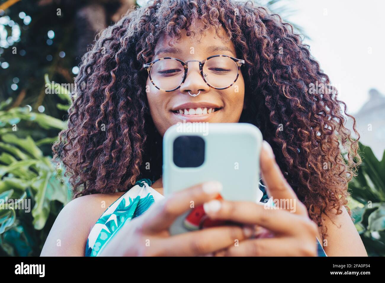 Primo piano della ragazza africana utilizzando il suo smartphone Foto Stock