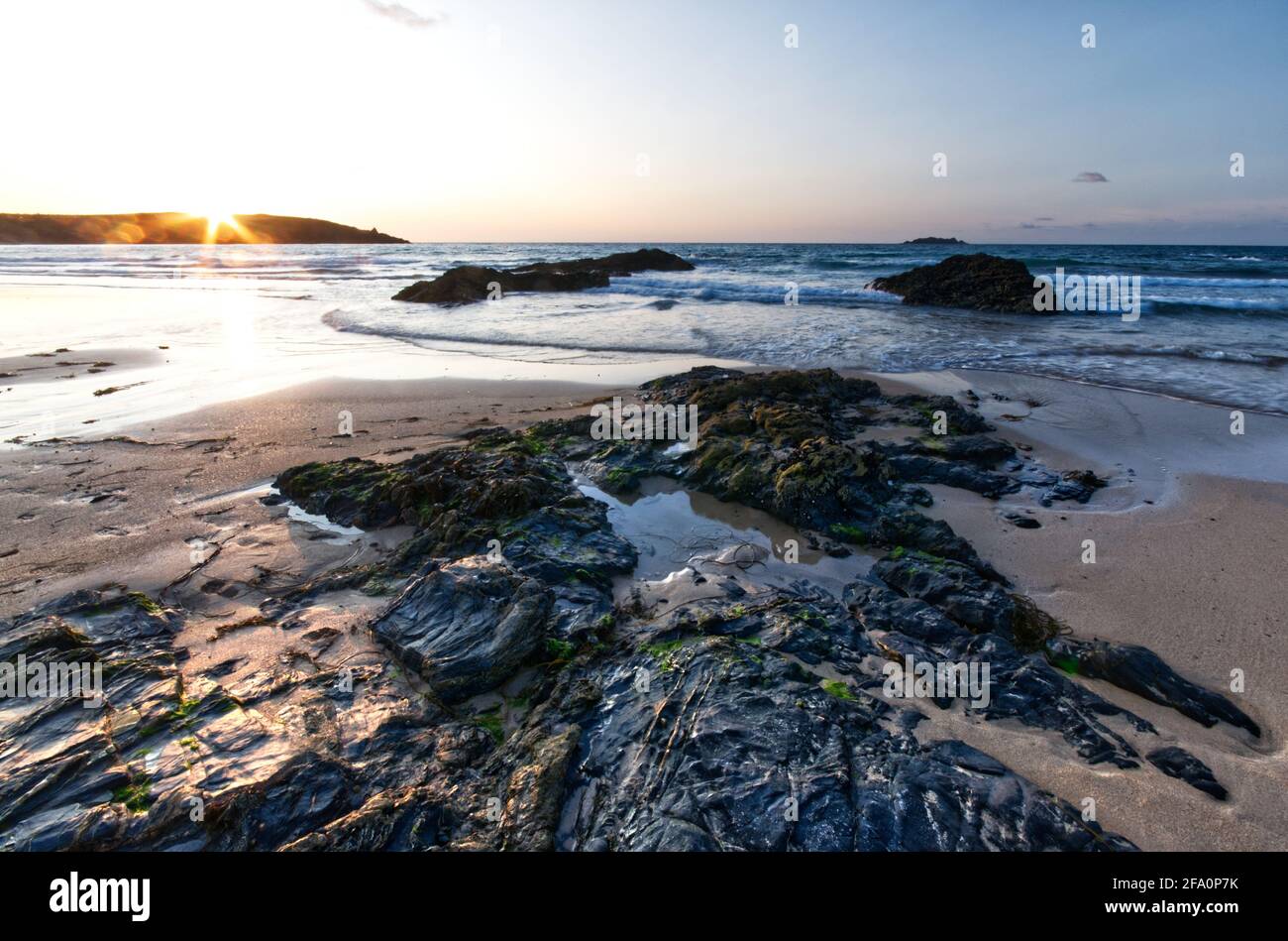 Tramonto da Harlyn Bay in Cornovaglia. La spiaggia si trova sulla costa della Cornovaglia, vicino a Padstow, ed è una famosa spiaggia con turisti e surfisti. Foto Stock