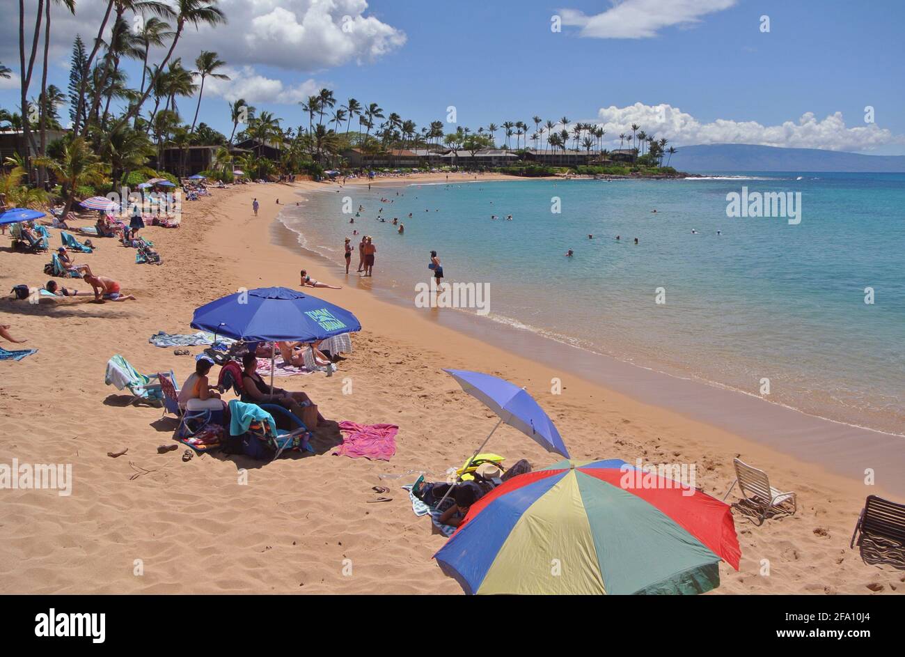 i turisti si rilassano sotto gli ombrelloni e nuotano e giocano sul Spiaggia sabbiosa soleggiata kaanapali ad ovest della città di Lahaina Sull'isola di Maui Hawaii usa Foto Stock