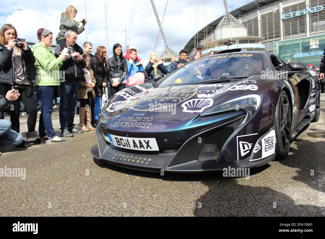 La parte anteriore DI un MSO Pearlescent McLaren 675LT Supercar ON Il Gumball 3000 Rally circondato come si lascia l'Etihad Stadio di Manchester Foto Stock