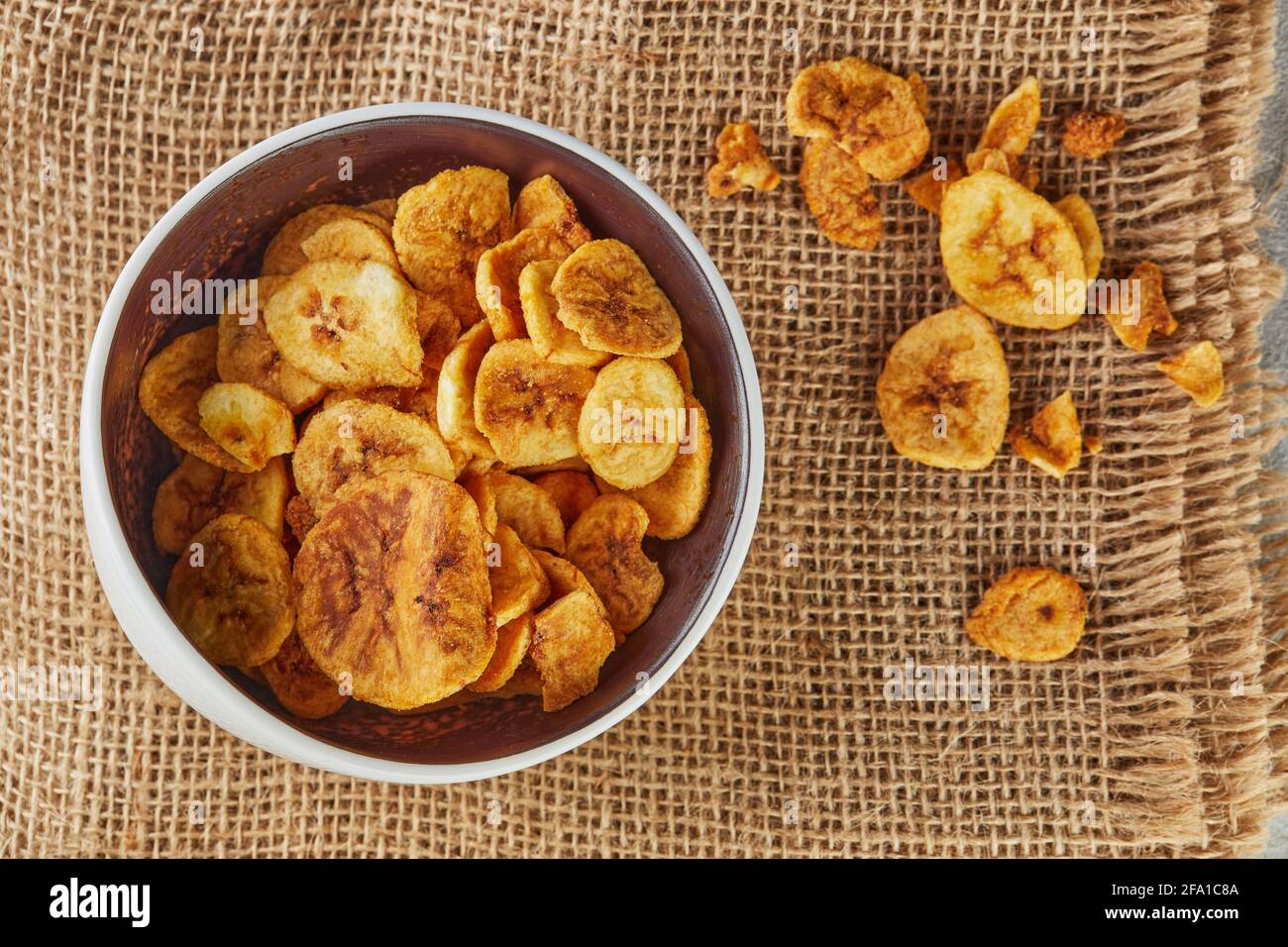 Banana chips cibo sano, frutta secca e patatine vegetali sane, sano vegan burlap snack. Disposizione piatta Foto Stock