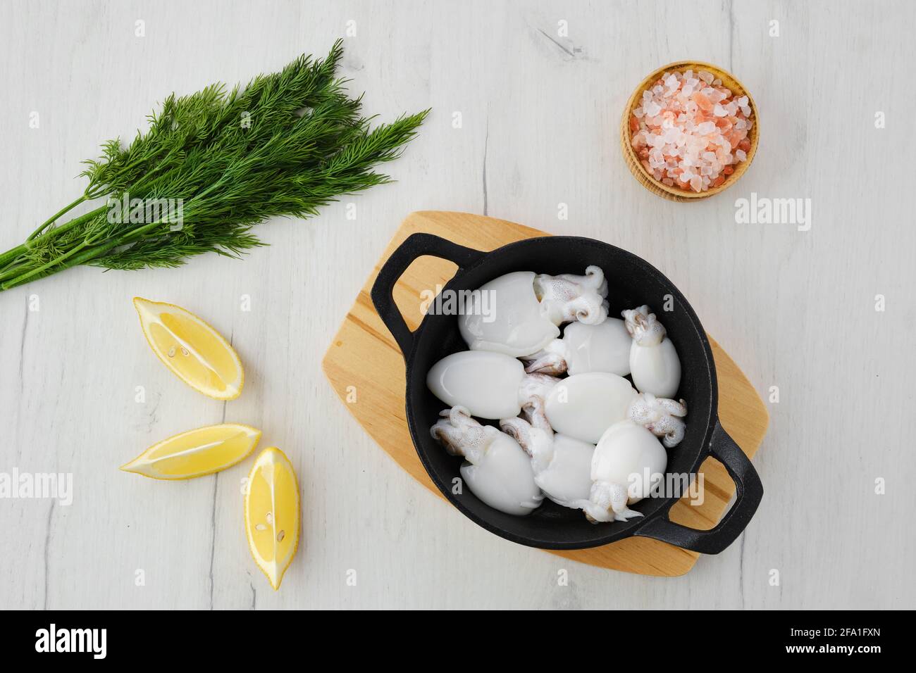 Vista dall'alto delle seppie in padella di ghisa con aneto, sale e limone  Foto stock - Alamy