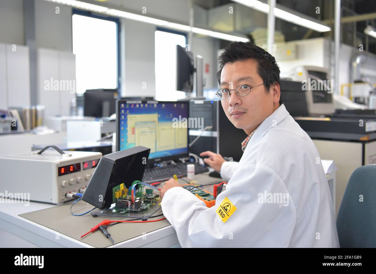 Engineer presso il posto di lavoro - il montaggio e lo sviluppo di circuiti elettronici in un moderno stabilimento Foto Stock