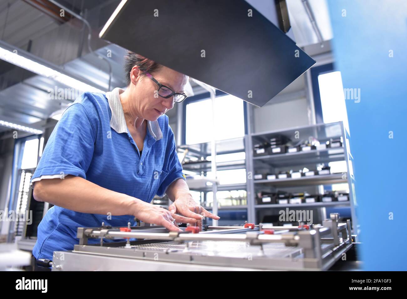 Donna che lavorano nella produzione di una fabbrica di componenti elettronici Foto Stock