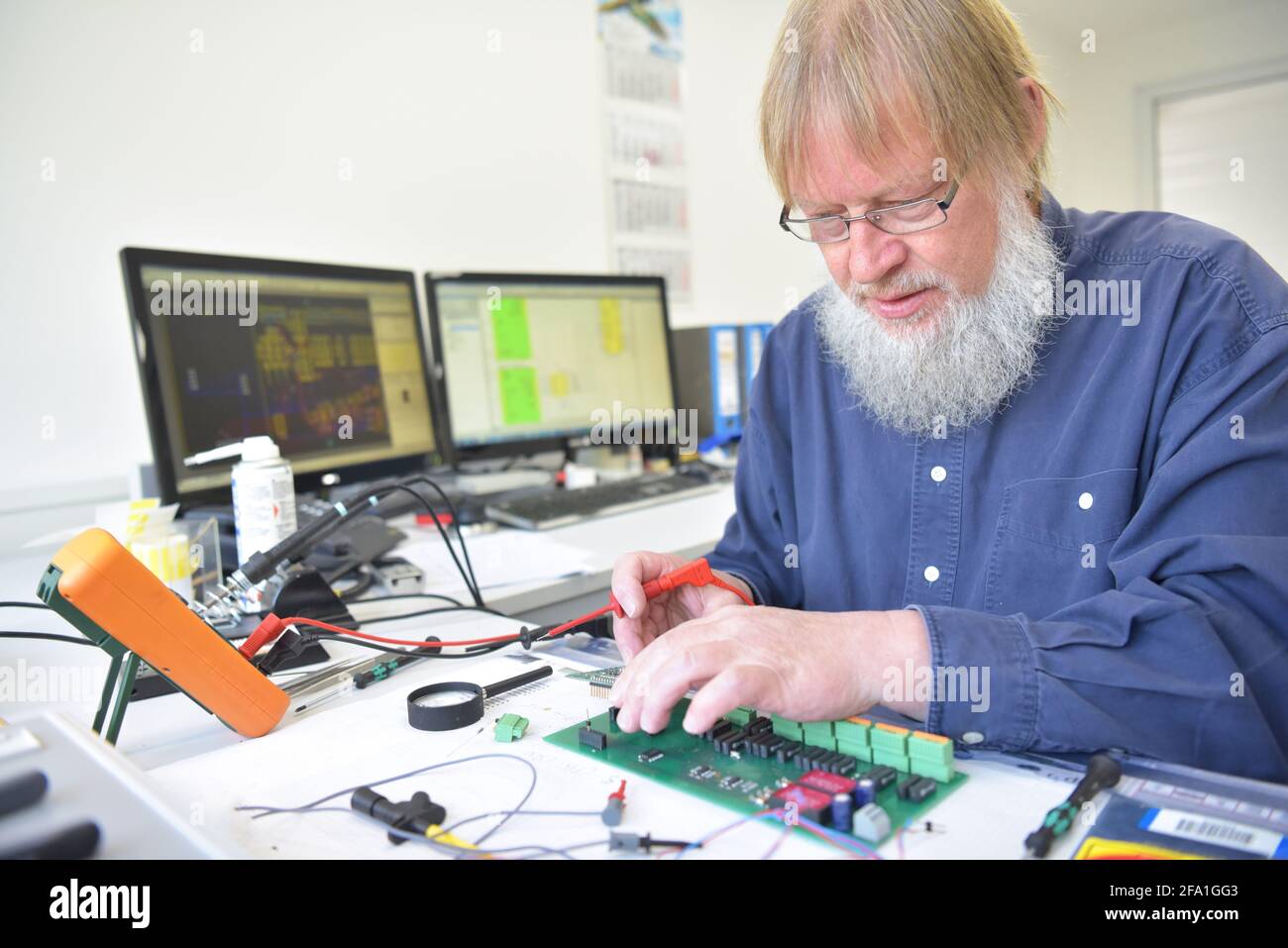 Engineer presso il posto di lavoro - il montaggio e lo sviluppo di circuiti elettronici in un moderno stabilimento Foto Stock