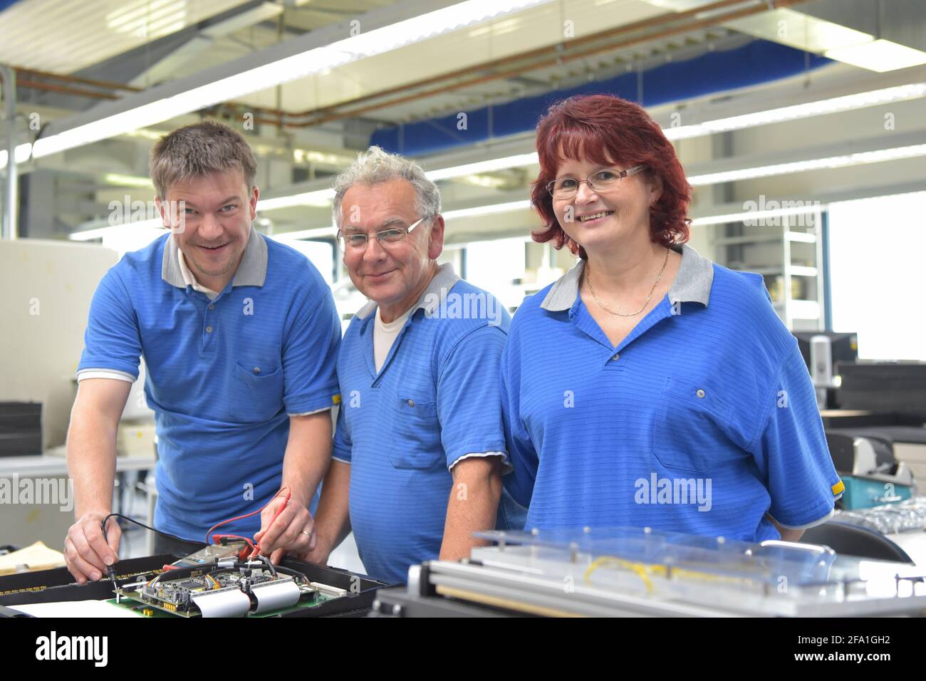 Il lavoro di squadra in un moodern fabbrica industriale - gruppo dei lavoratori nella produzione e sviluppo di elettronica Foto Stock