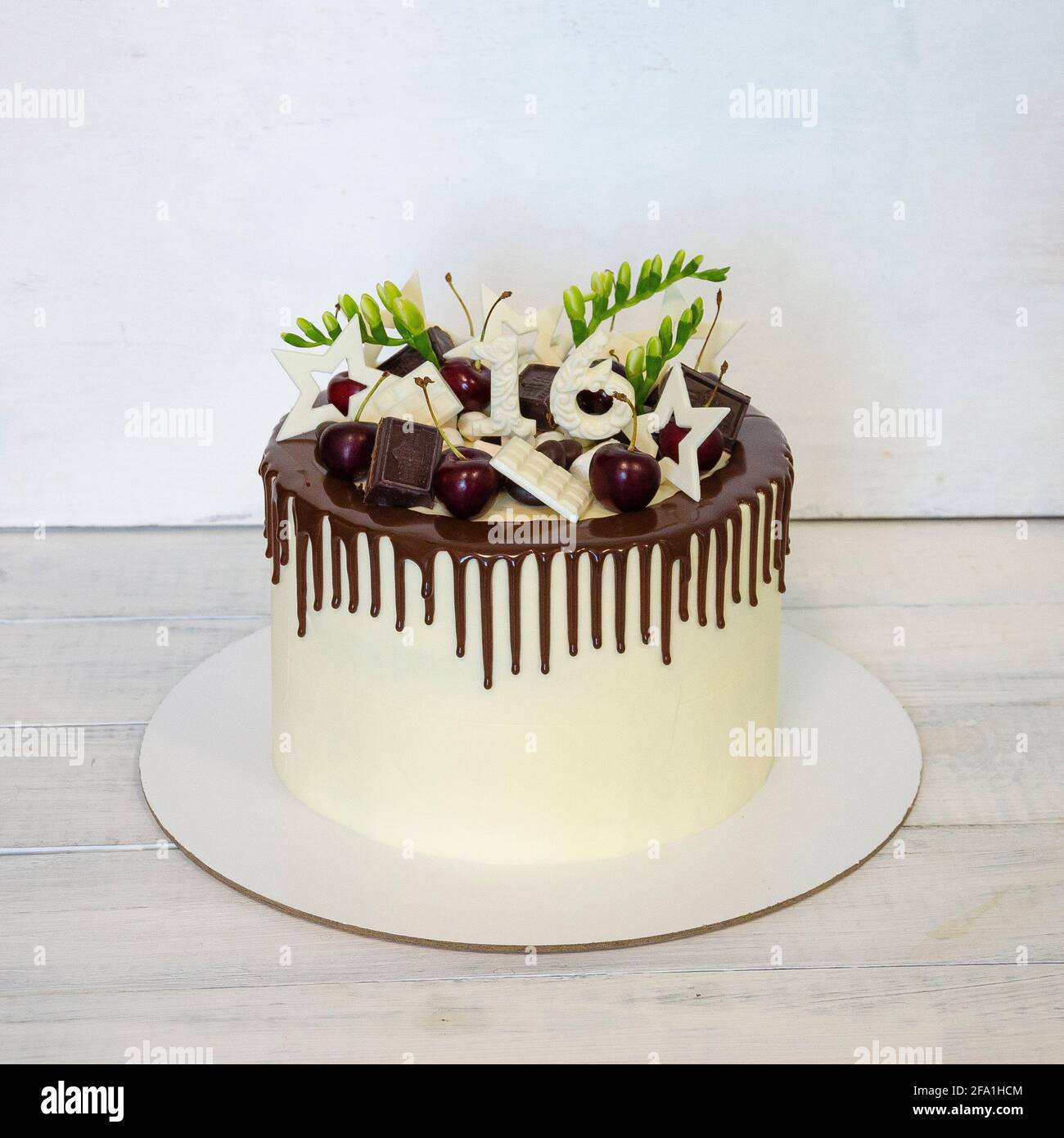 torta di compleanno con gocce di colore per il 16° anniversario con decorazione al cioccolato Foto Stock