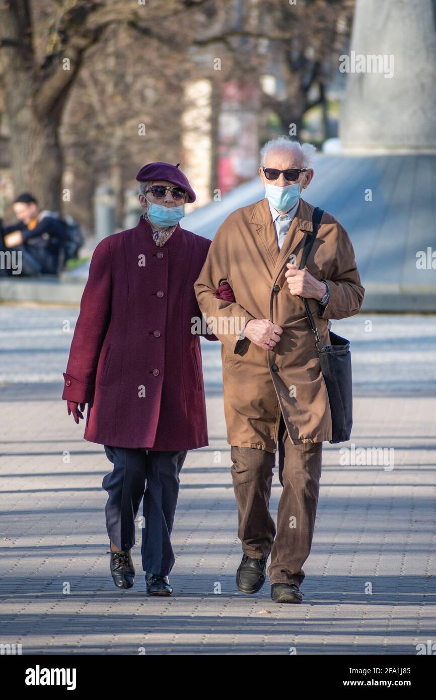 Coppia di anziani vaccinati indossando maschera in città, verticale Foto Stock
