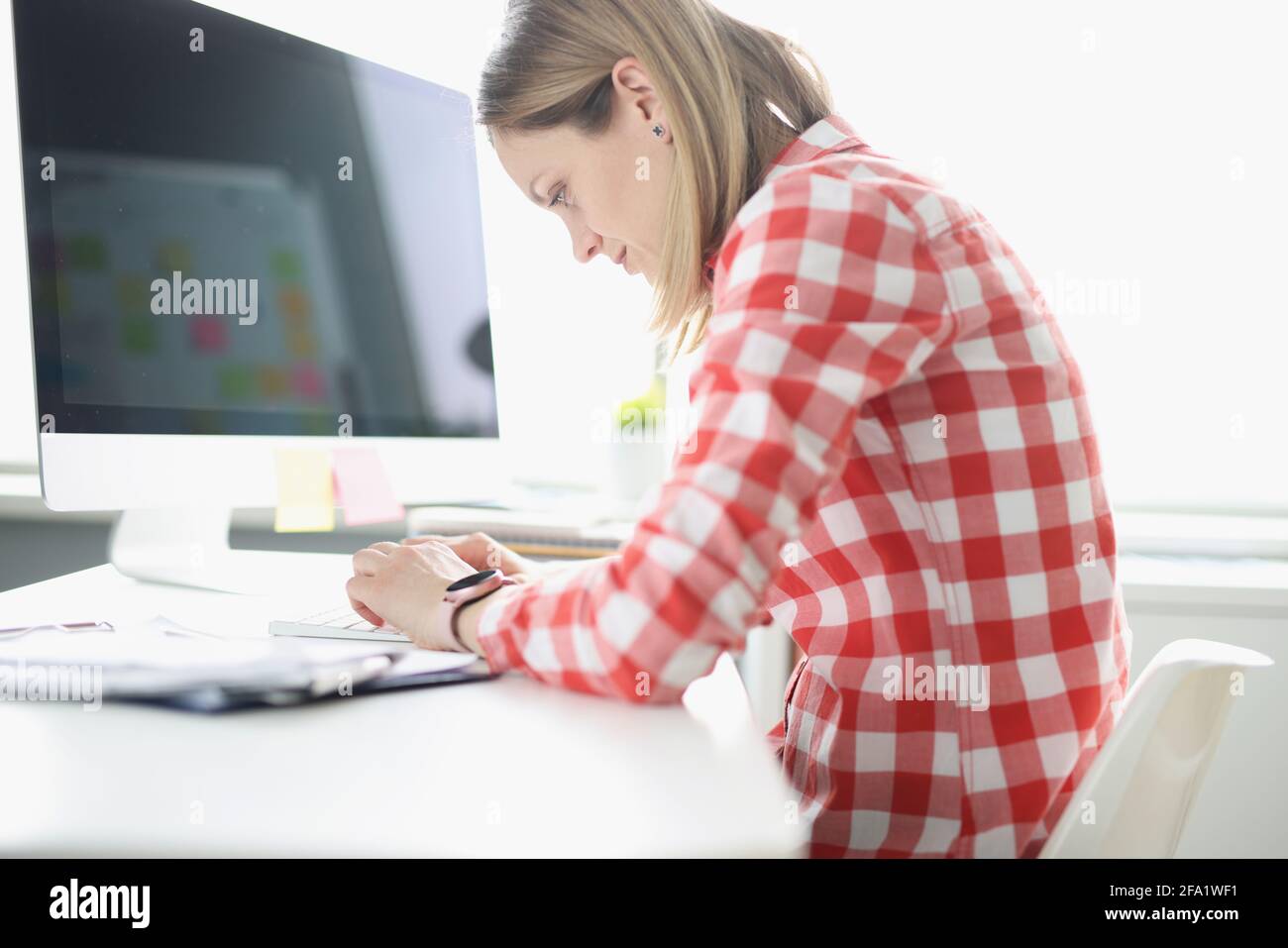 Donna appesa che scrive sulla tastiera del computer al tavolo Foto Stock