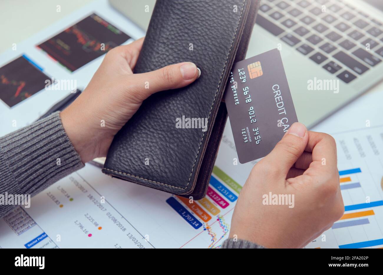 Uomo d'affari, portafoglio in pelle con carte di credito sulla scrivania dell'ufficio. Concetto di affari, finanze e denaro. Foto Stock