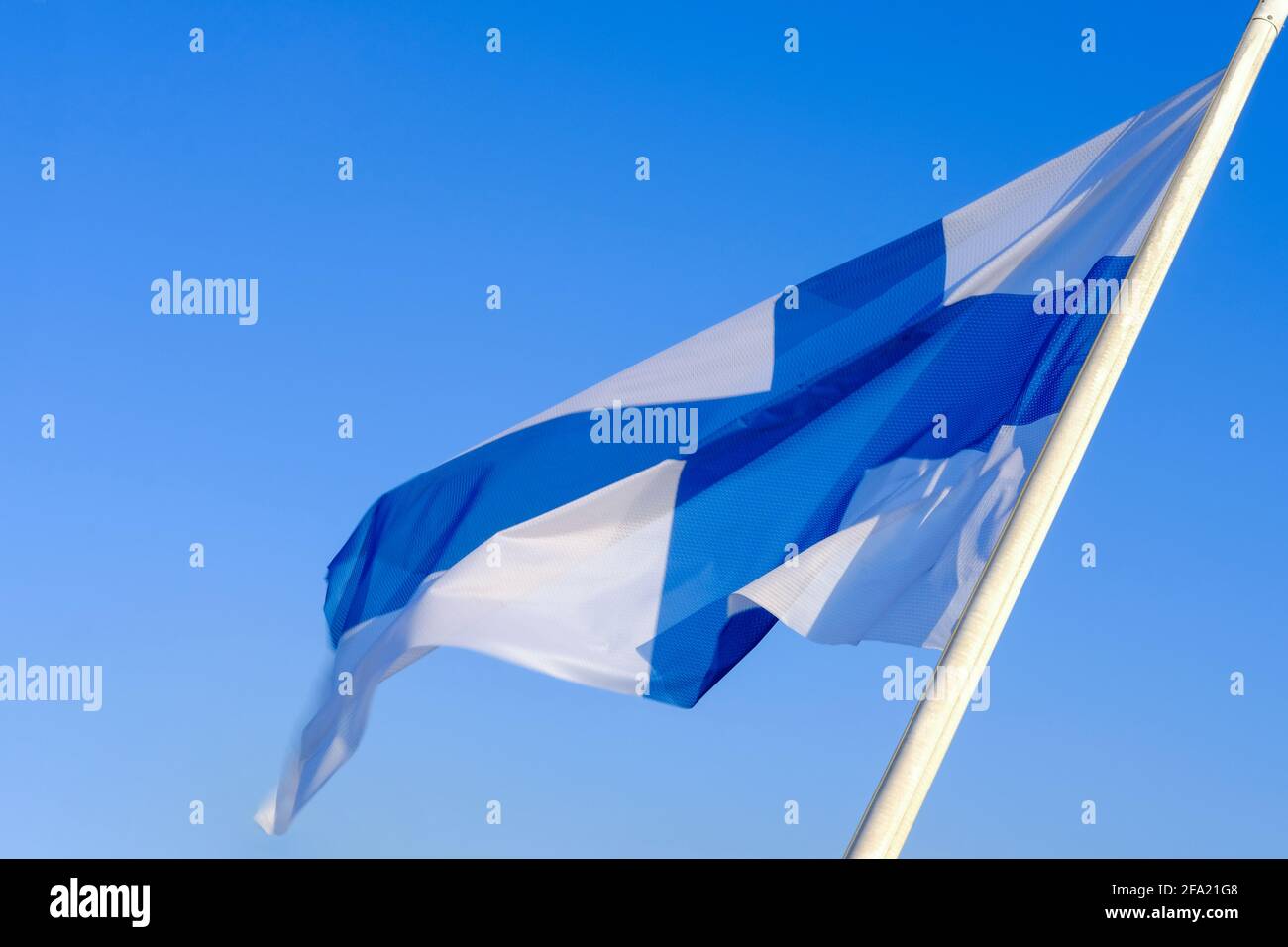 Bandiera nazionale della Finlandia che sventolava sul vento contro il cielo blu chiaro. Foto Stock