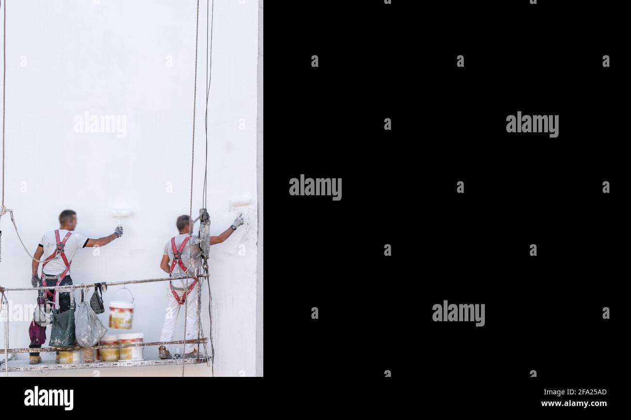 Pittura di facciata impalcature e pittori sfocati con rullo di vernice Foto Stock