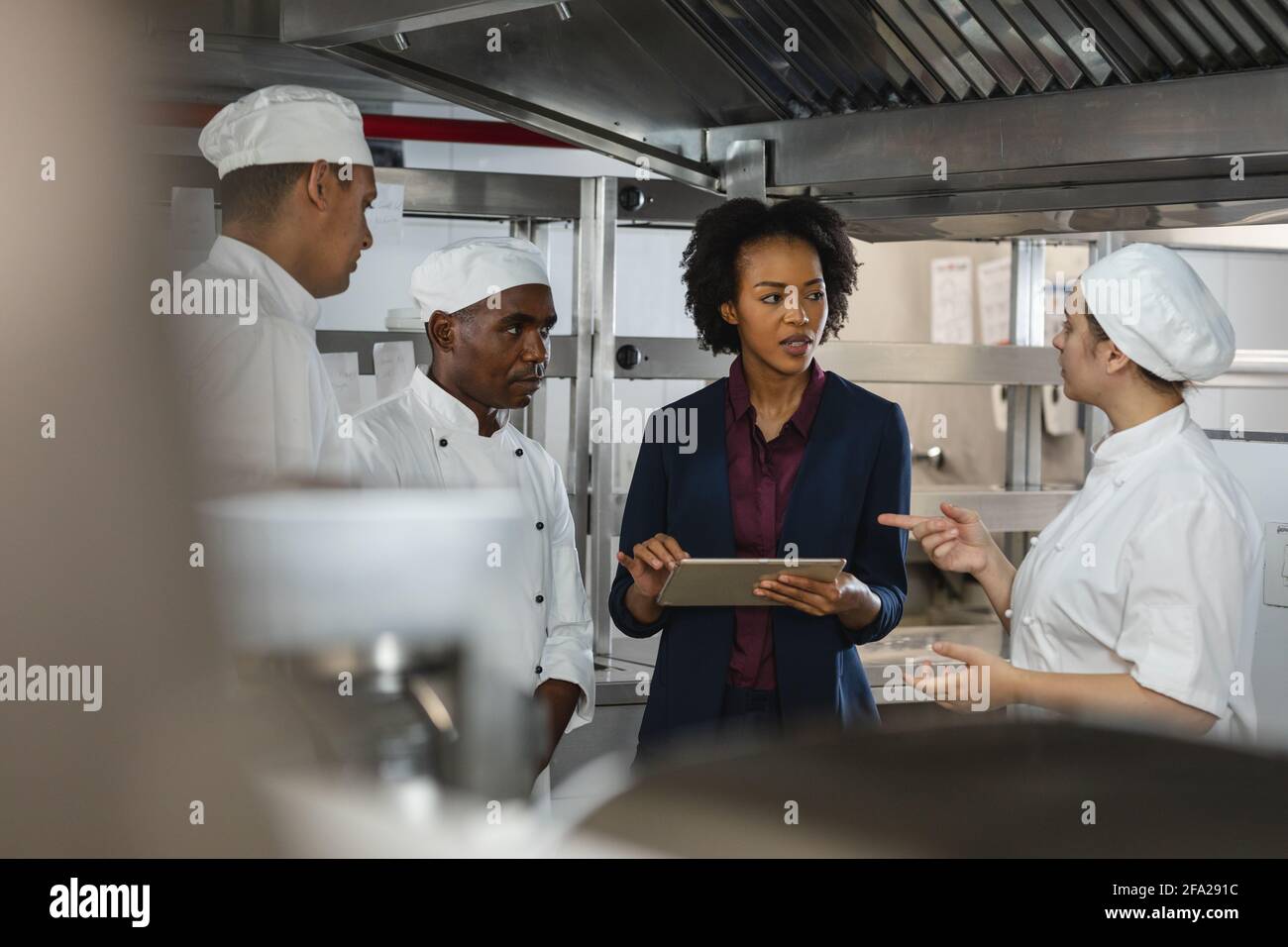 Gruppo vario di chef professinenti che si incontrano con il direttore della cucina Foto Stock