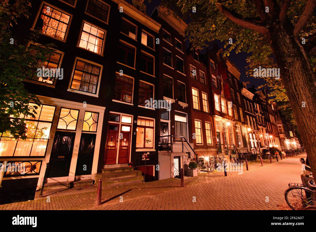 Notte ad Amsterdam, biciclette e strade alla luce delle lampade da strada. Notte. Foto Stock