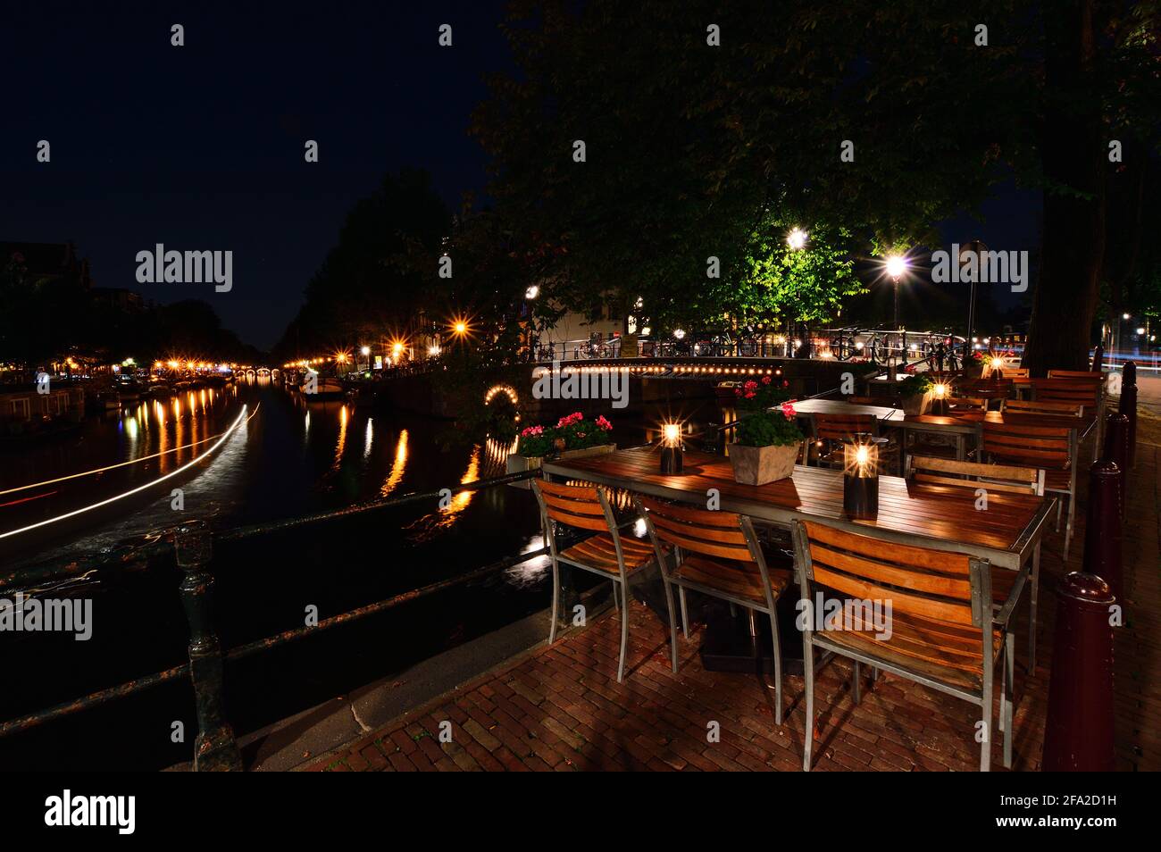 Una notte ad Amsterdam. Strisce chiare di una barca che scorre lungo il canale. Estate. Foto Stock