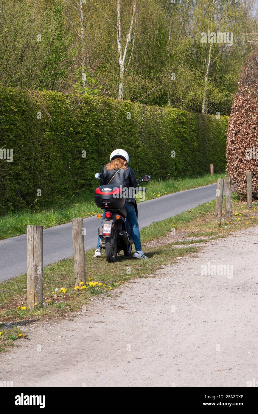 Sint Gillis WAAS, Belgio, 21 aprile 2021, Girl on scooter si ferma e guarda il suo smartphone Foto Stock
