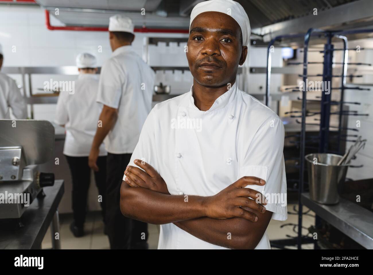 Ritratto di chef professionista africano americano con colleghi sfondo Foto Stock