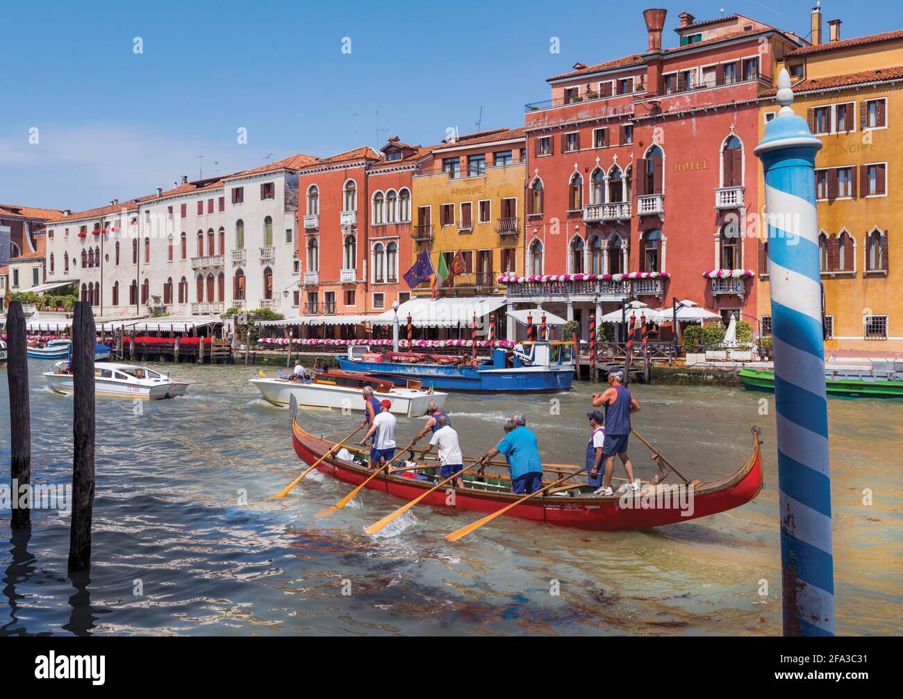 Venezia, Italia. Sette vogatori e un timoniere un gondola lungo il Canal Grande. Barche come questa sono usate in competizioni. Lo stile del canottaggio - Foto Stock