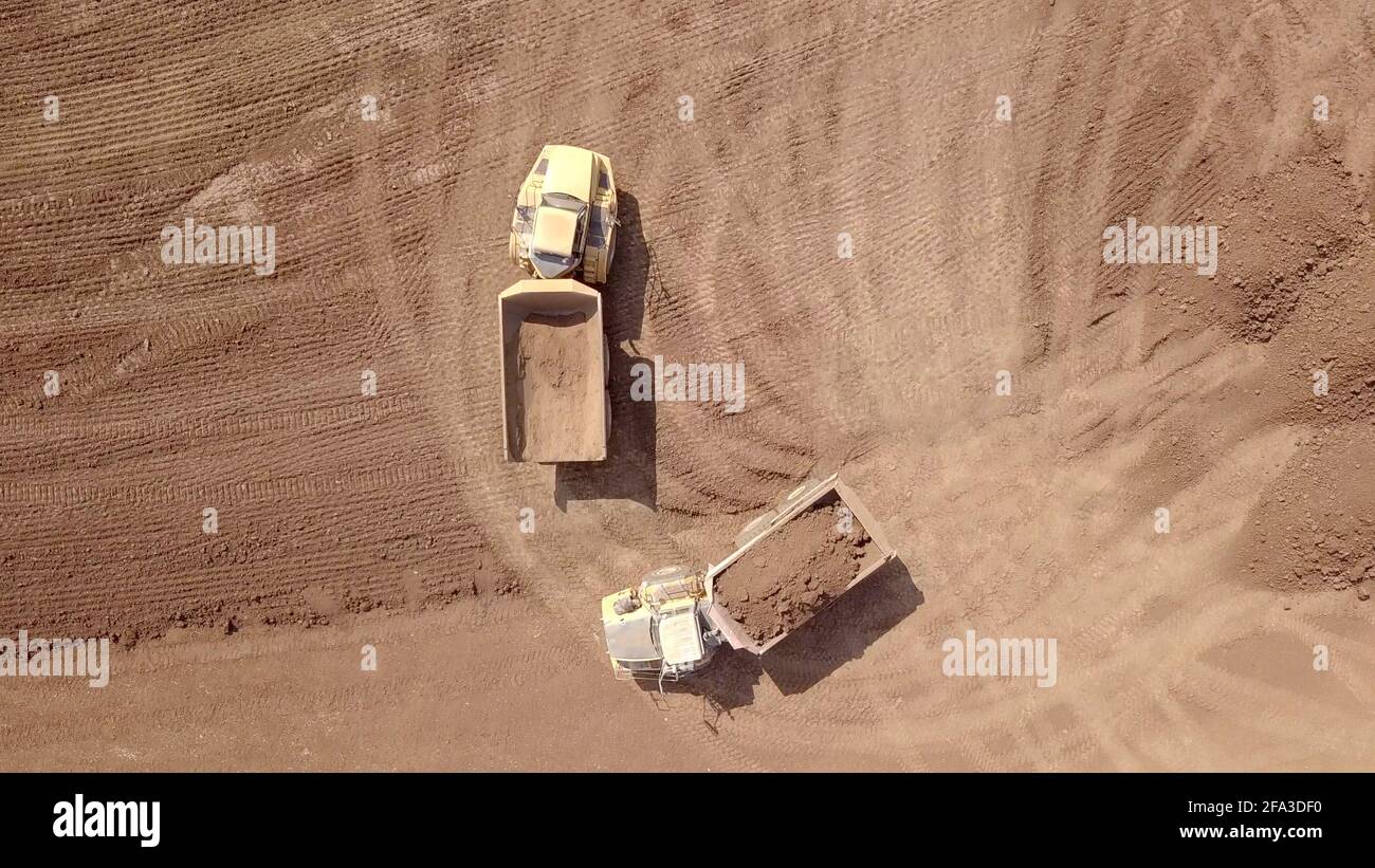Dumper per impieghi gravosi caricato con terreno in un nuovo cantiere. Vista aerea. Foto Stock