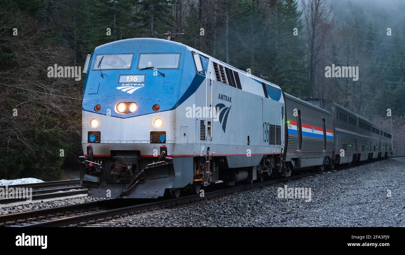 L'Empire Builder dell'Amtrak si avvicina al Cascade Tunnel mentre cala la notte sul treno Sleeper di Seattle a Chicago. La pioggia sta cadendo rendendo questa scena umida Foto Stock