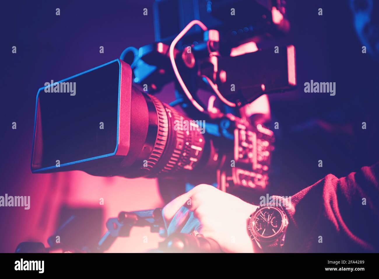 Videocamera moderna con teleobiettivo e operatore. Digital Motion Picture Equipment. Foto Stock