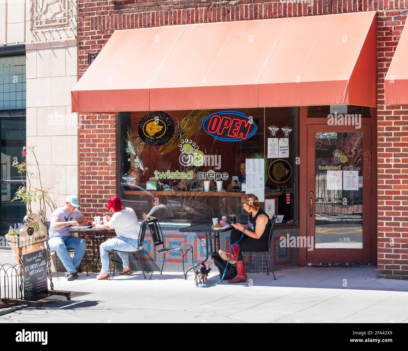 ASHEVILLE, NC, USA-11 APRILE 2021: La caffetteria Twisted Crepe e pasticceria nel centro citta'. Tre persone siedono ai tavoli esterni. Foto Stock