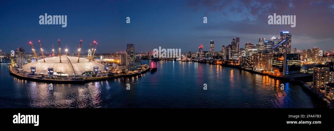L'arena O2 e Canary Wharf London, vista aerea al tramonto che guarda sul fiume tamigi. Foto panoramica del drone all'ora blu che mostra le luci della città Foto Stock