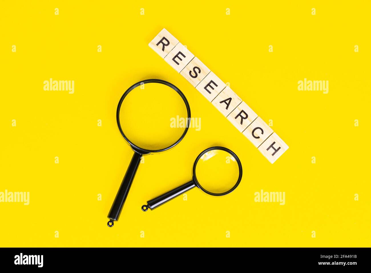 Lente d'ingrandimento nera con testo di ricerca su sfondo giallo chiaro con spazio per la copia. Analisi statistica e ricerca scientifica. Foto Stock