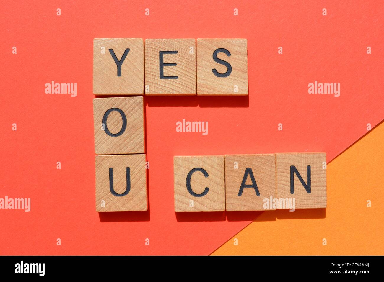 Sì, parole motivazionali in lettere alfabetiche in legno isolate su sfondo dai colori vivaci Foto Stock