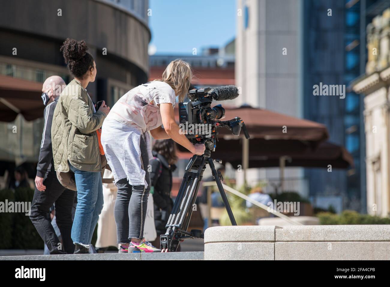Una donna che opera una telecamera all'aperto a Birmingham, Regno Unito. Foto Stock