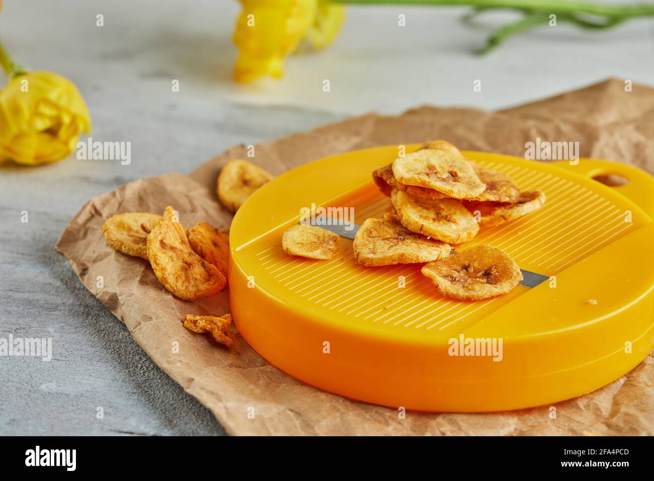Banana chips cibo sano, frutta secca e patatine vegetali sane, sano snack vegan con taglierine. Foto Stock