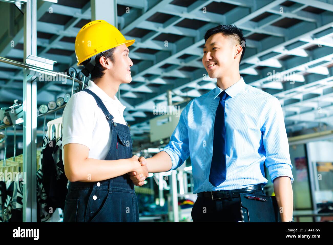 Lavoratore o production manager e proprietario, CEO di controller o agitare le mani in una fabbrica Foto Stock