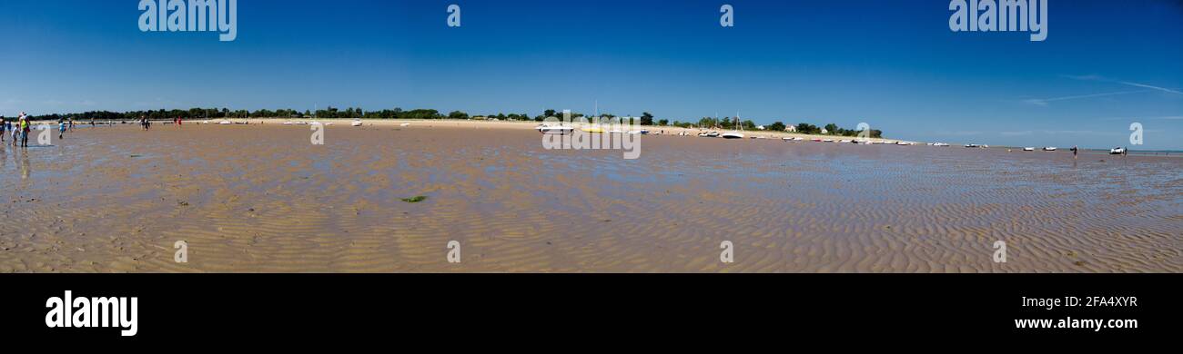 Panorama di persone alla ricerca di crostacei a bassa marea a Les Portes-en-Ré sull'isola di ile de re in Francia e alcune barche che si stende sulla sabbia. E un Foto Stock