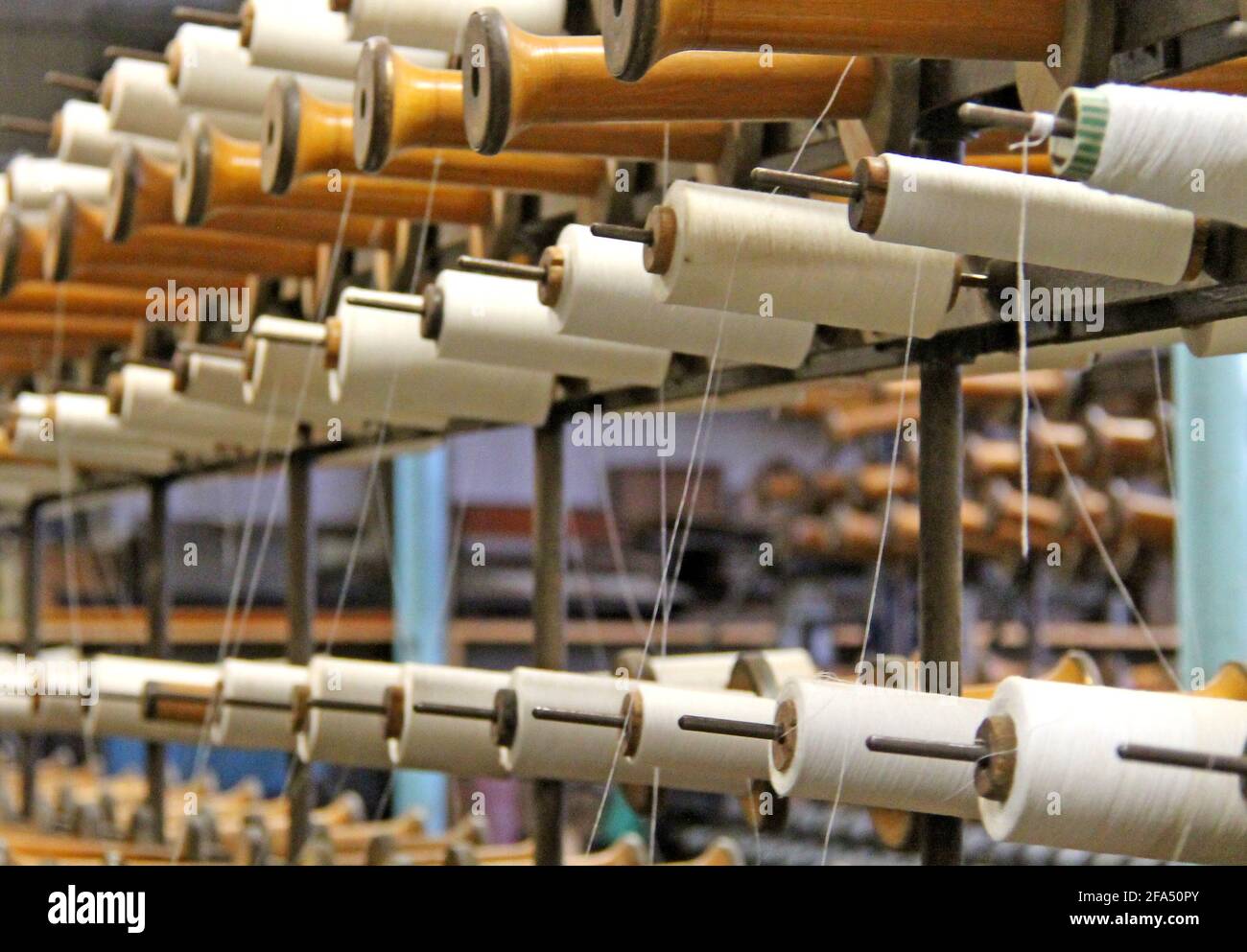 Il cotone si rocche su una macchina tessile d'epoca. Foto Stock