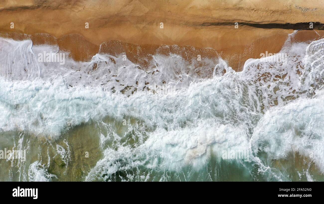 Mare costa con acqua limpida e molte onde che si infrangono in aereo immagine Foto Stock