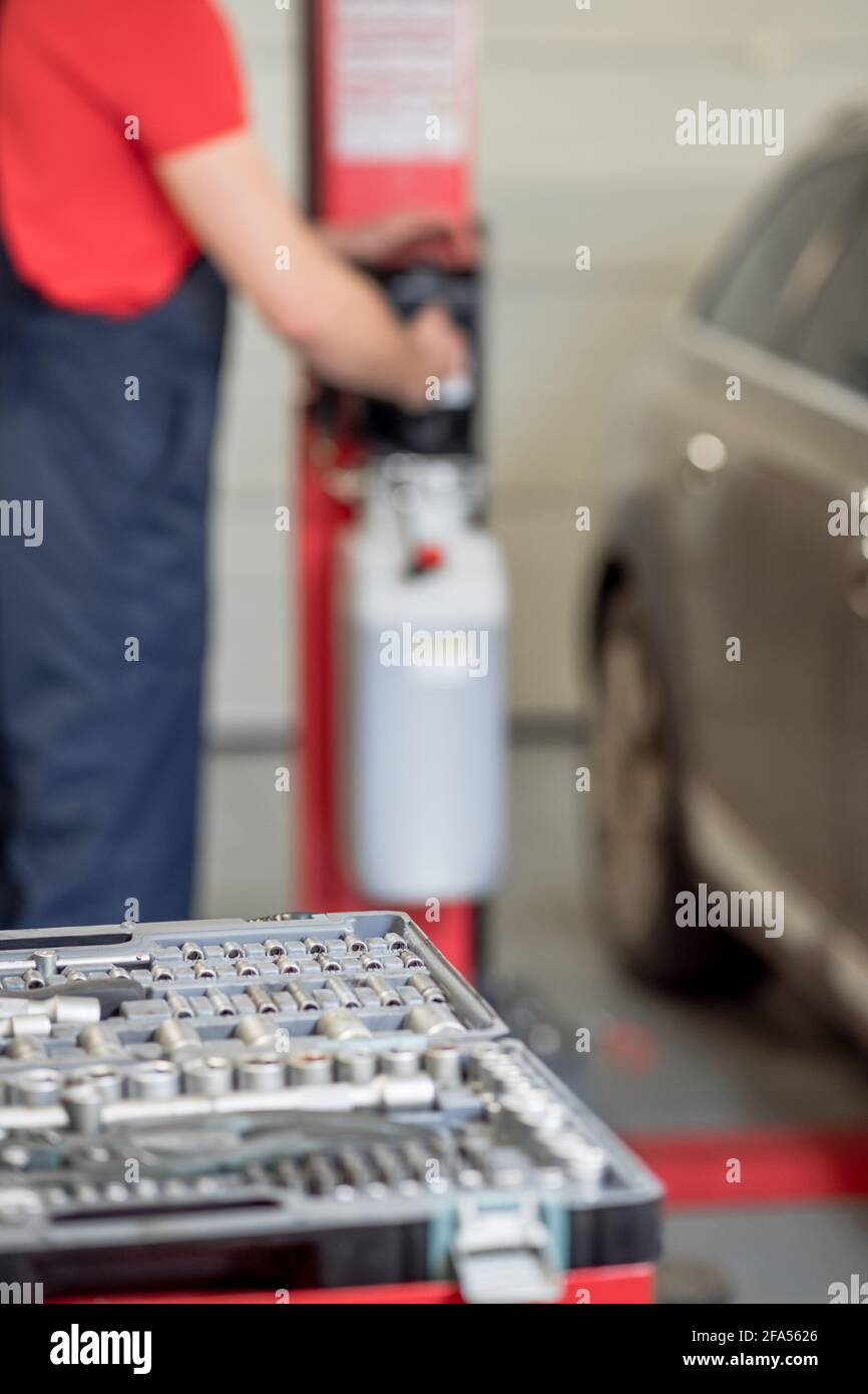 Attrezzo speciale in officina e meccanico dietro Foto Stock