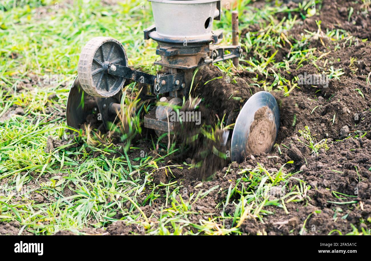 macchina aratrice che lavora con terreno nei terreni agricoli primaverili Foto Stock