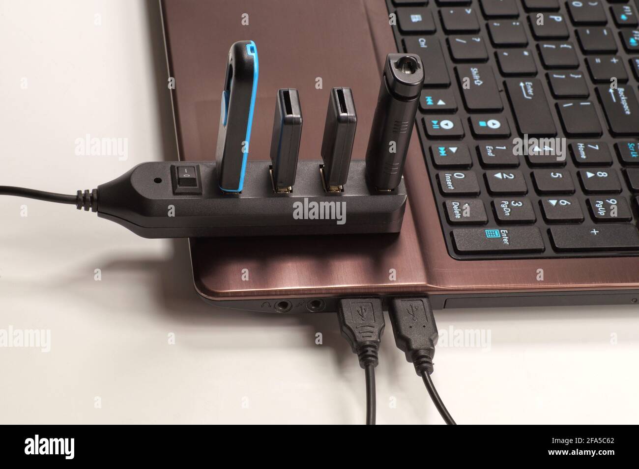 Hub USB completamente utilizzato (ogni dispositivo è collegato a un dispositivo) collegato al laptop. Foto Stock