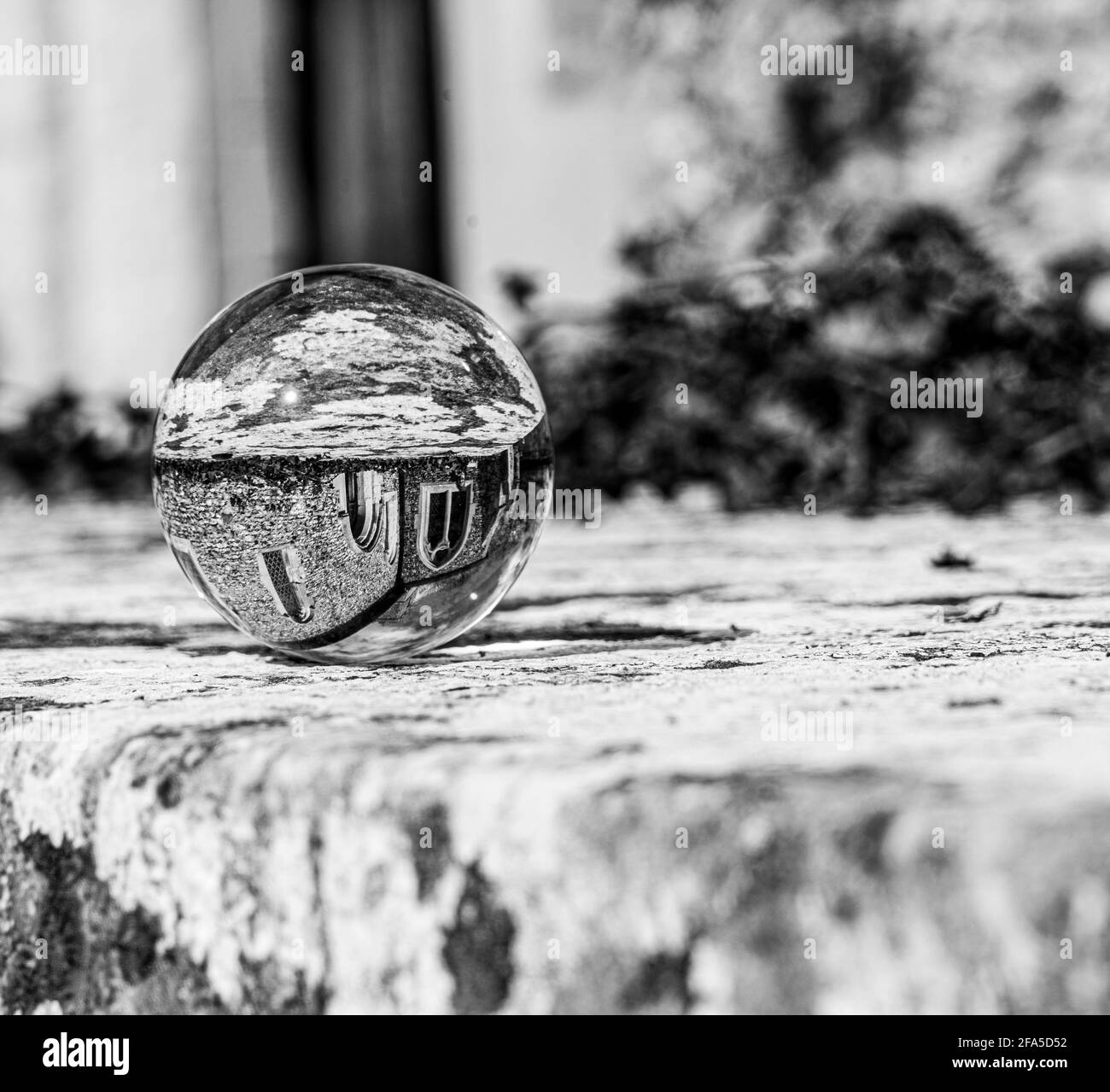 Crystal Photo Ball sulla superficie in granito grigio che riflette l'immagine di Chiesa e edificio storico sotto il sole estivo Foto Stock