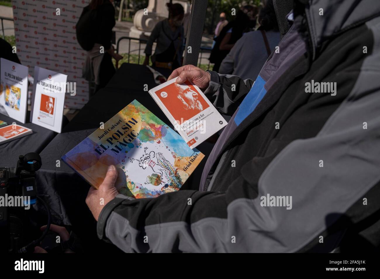 Barcellona, Spagna. 23 Apr 2021. Un lettore attende la firma di Jordi Cuixart mentre tiene due edizioni dei suoi libri.Jordi Cuixart, presidente del leader culturale e dell'indipendenza del 'mnio, utilizzando uno straordinario permesso carcerario, firma i suoi libri durante il giorno di Sant Jordi, del Libro e della Rosa. Credit: SOPA Images Limited/Alamy Live News Foto Stock