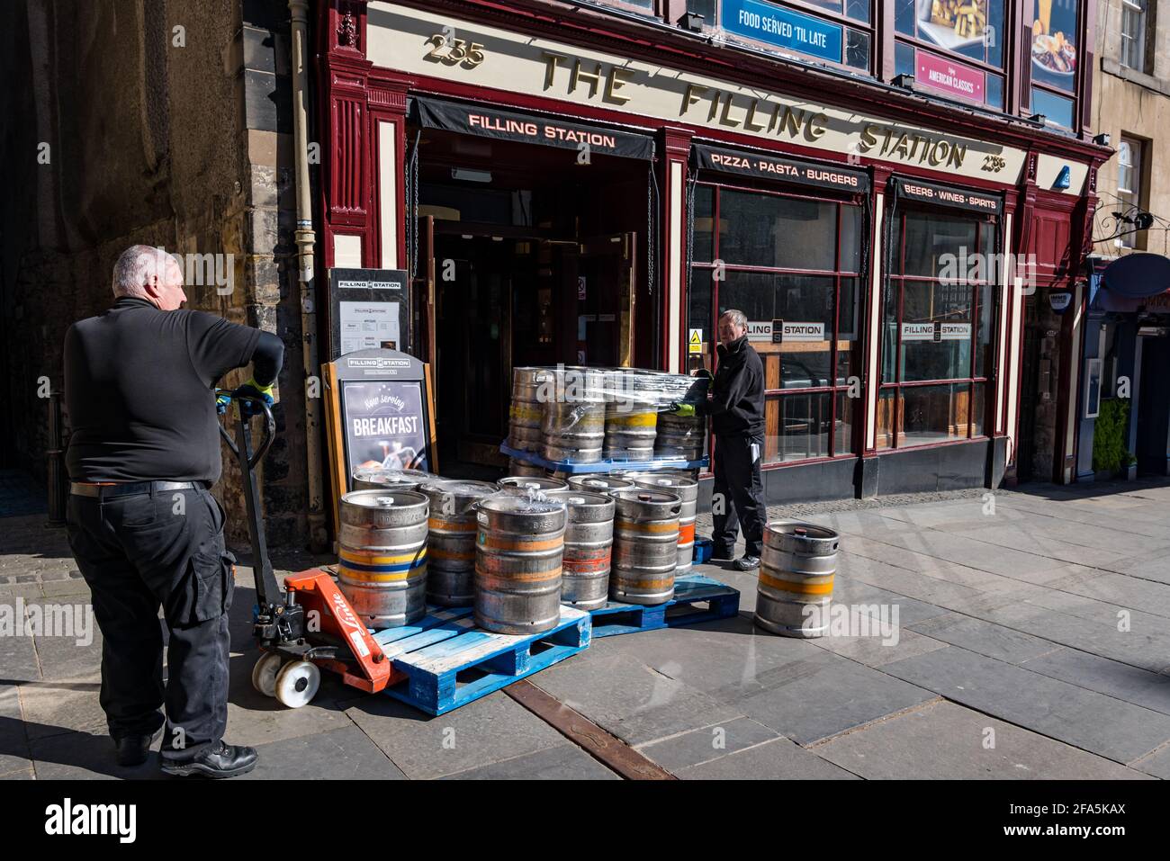 Royal Mile, Edimburgo, Scozia, Regno Unito. 23 Apr 2021. I pub si preparano alla riapertura: Il pub della Filling Station riceve un'ampia consegna di barili di birra in preparazione dell'apertura di lunedì prossimo, quando le restrizioni di blocco della pandemia scozzese faciliteranno e consentiranno il servizio all'aperto Foto Stock